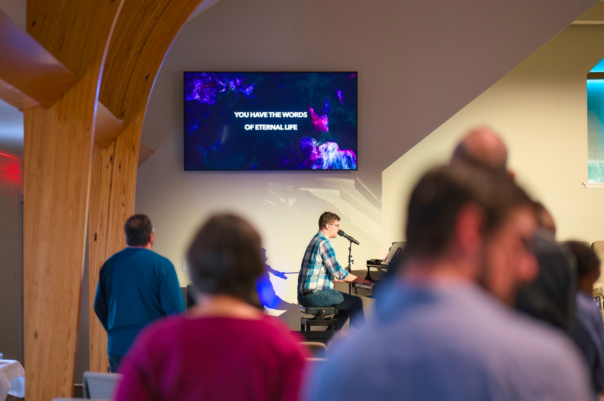 The congregation standing together in worship at Lucy Baptist Church, the words “You have the words of eternal life” on the screen.
