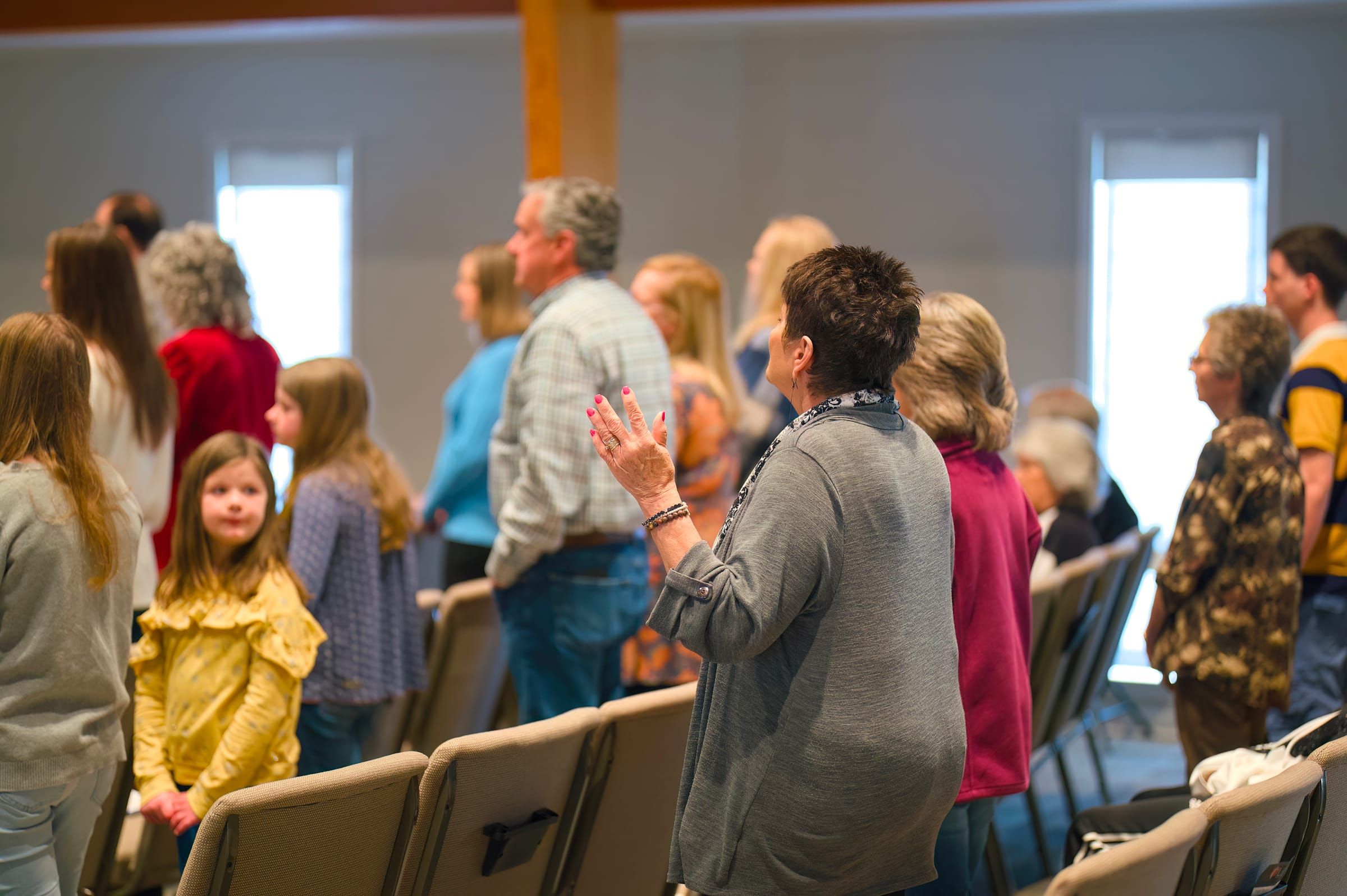 The congregation standing together in song during Sunday worship at Lucy Baptist Church, children and grandparents side by side.