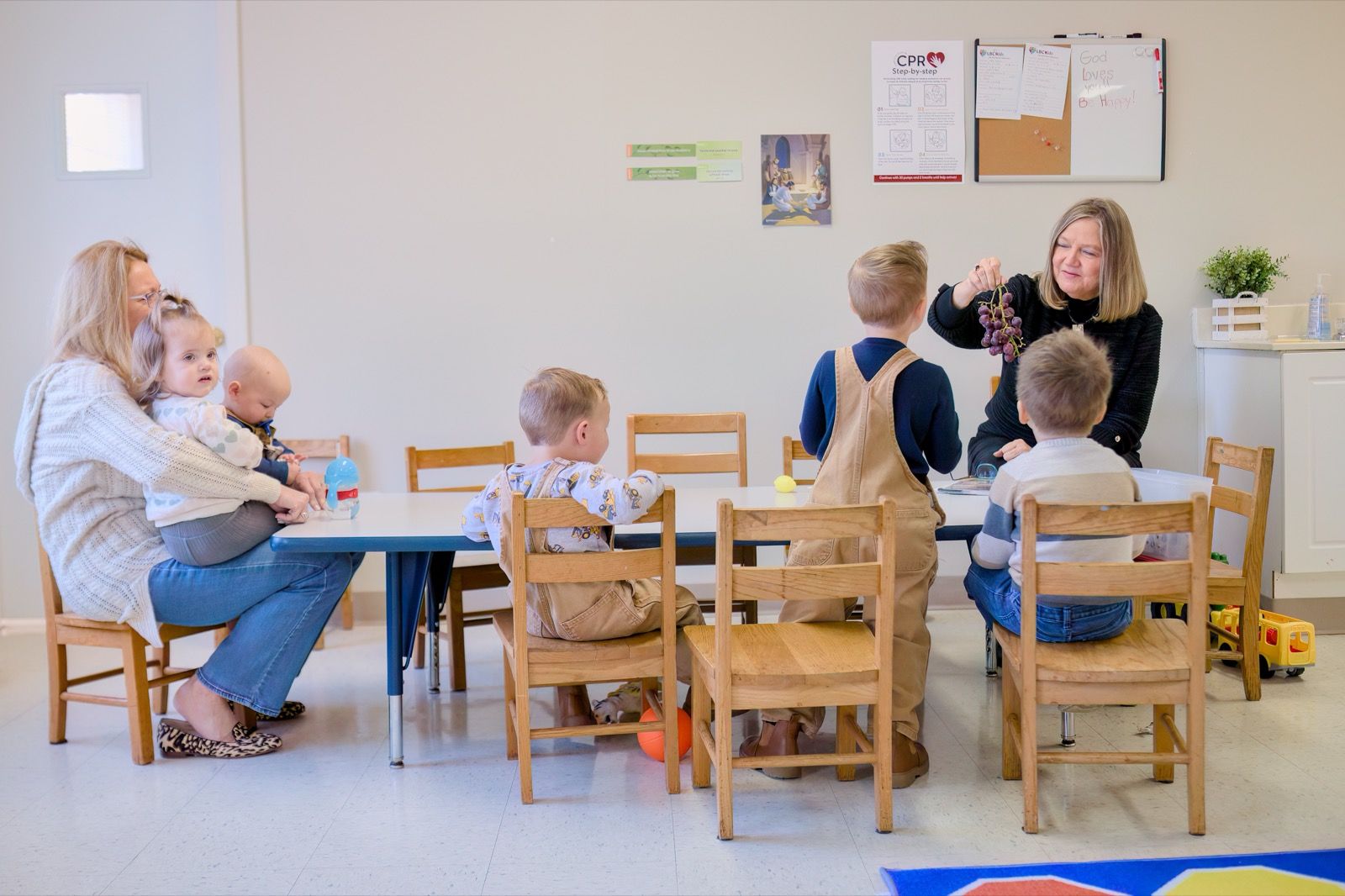 Volunteers caring for young children around a table in the Lucy Baptist Church kids wing.